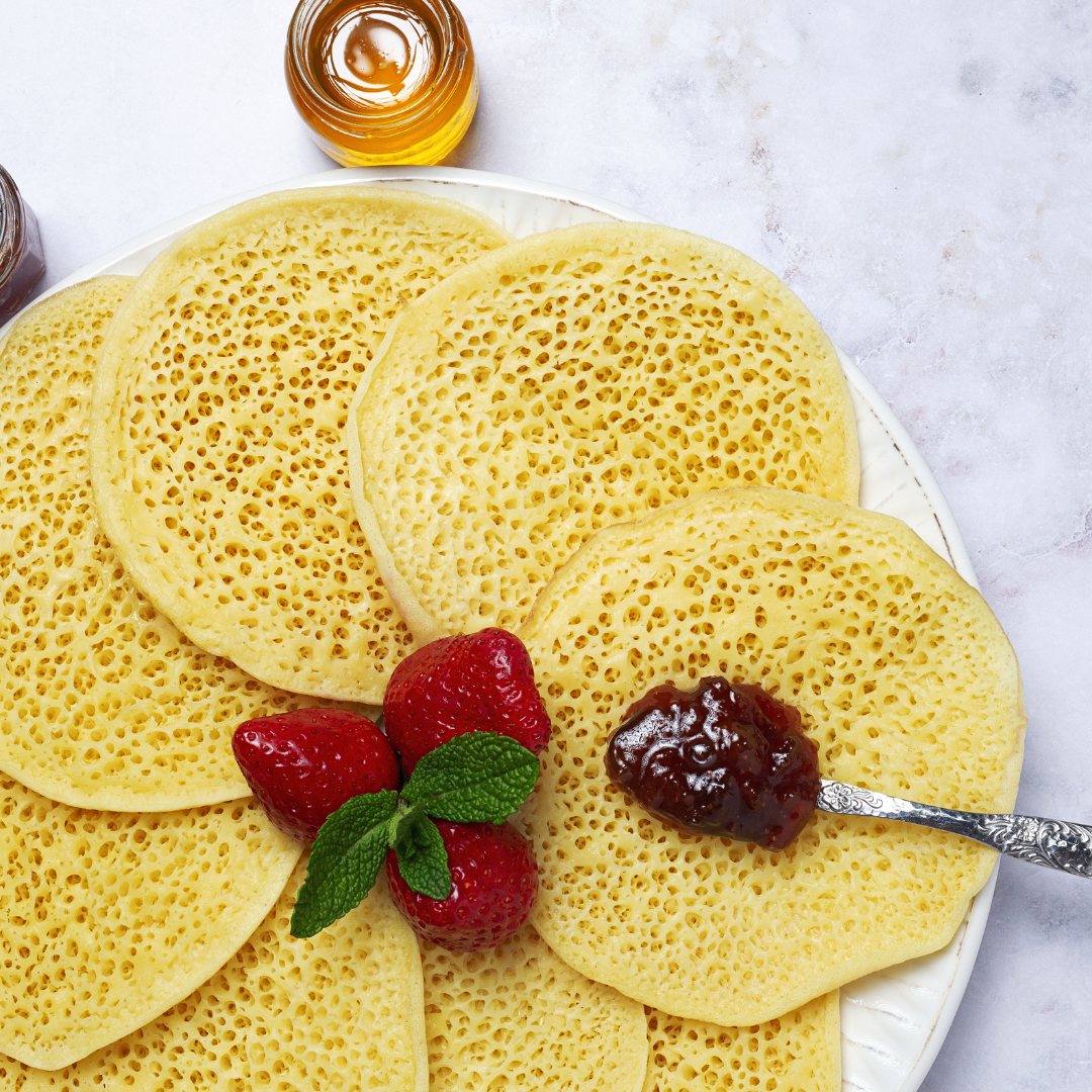 Thousand-hole baghrir pancakes served with strawberries and jam
